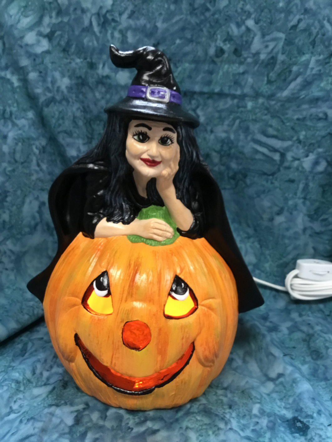 Halloween Witch Leaning On Pumpkin with Light